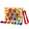 A wooden Montessori Bee Trap game featuring colorful clip beads arranged in a honeycomb pattern.