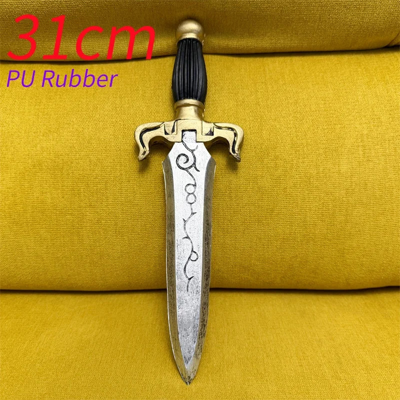 A silver dagger with a gold hilt and black pommel resting on a yellow fabric background.