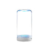 A clear cylindrical electric toothbrush with a blue light feature sits on a white base.