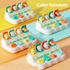A set of Montessori pop-up animal toys in various colors arranged on a white tray.