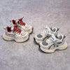 A pair of red and white breathable mesh kids running sneakers with cushioned soles resting on a gray surface.