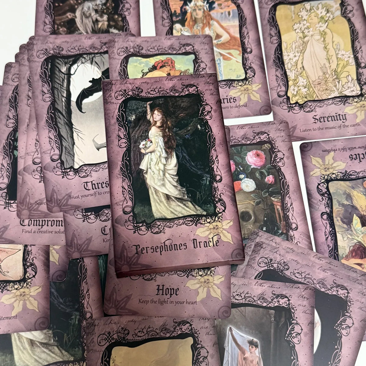 A collection of purple and gold oracle cards featuring dark, mystical imagery and goddess guidance themes.