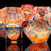 A collection of handmade liquid core polyhedral dice in orange and iridescent galaxy finishes.