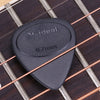 A black non-slip nylon guitar pick labeled Mideal resting on a wooden fretboard.