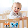 Two plush animal toys, an orange fox and a blue dog, are hanging from a wooden railing.