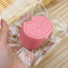 A pink cat shaped squishy stress relief toy is shown inside a clear plastic pouch.