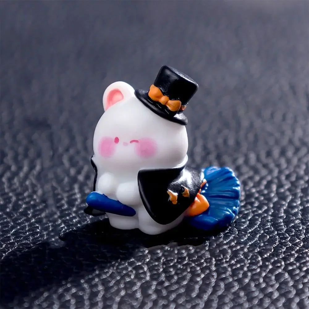 A white cartoon bear figurine wearing a black top hat and blue accents, displayed on a dark surface.