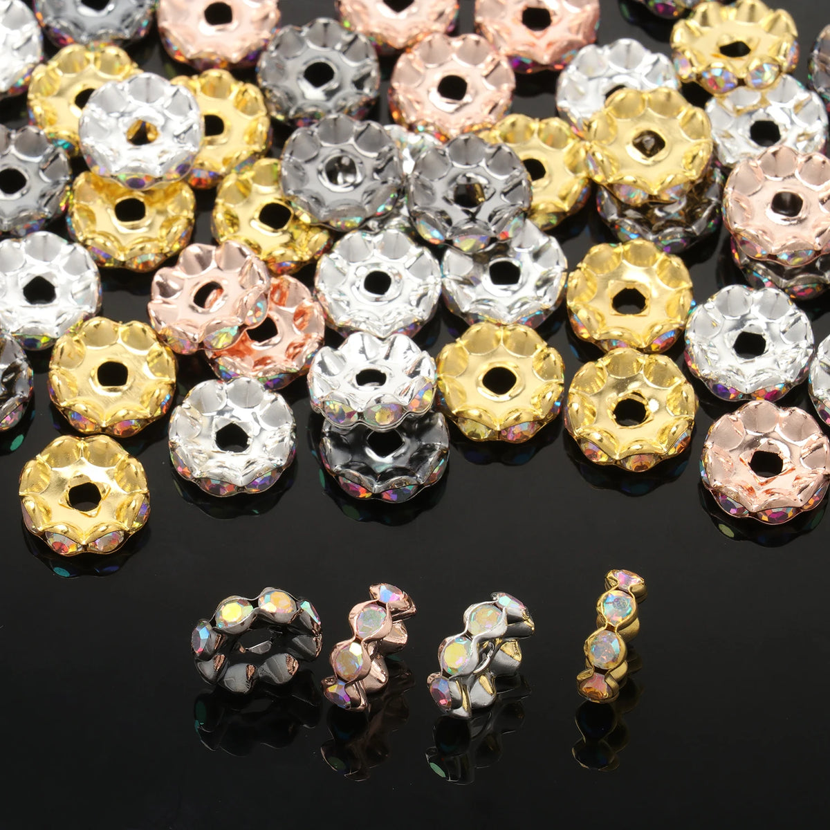 A close-up of various 12mm crystal rhinestone spacer beads in gold, silver, and rose tones.