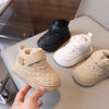 A pair of beige quilted toddler winter snow boots with soft soles and Velcro closures are shown on a light surface.