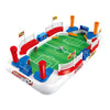 A mini tabletop foosball game featuring two teams, complete with flip control mechanisms and a green playing field.