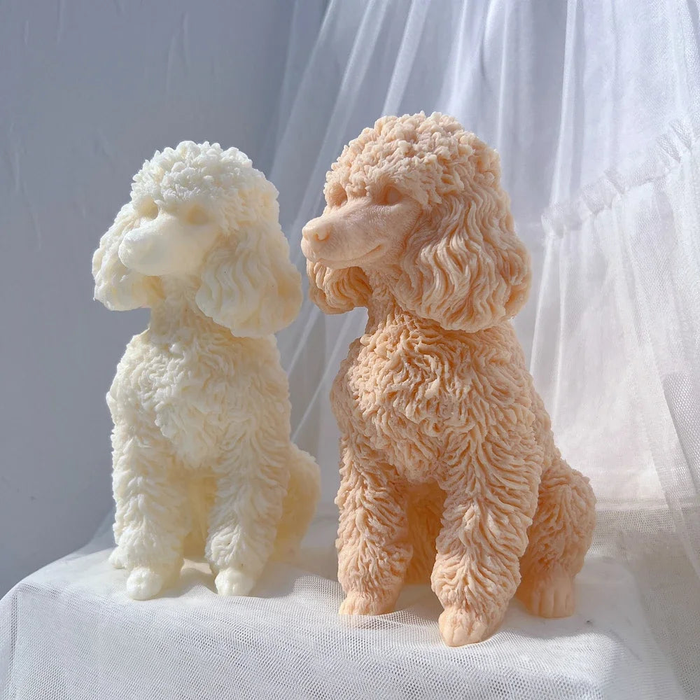 A pair of fluffy poodle dog silicone candle molds in white and peach colors sitting on a white fabric.
