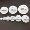 A collection of white silicone sphere molds with various diameters labeled in millimeters, ranging from 80mm to 100mm.