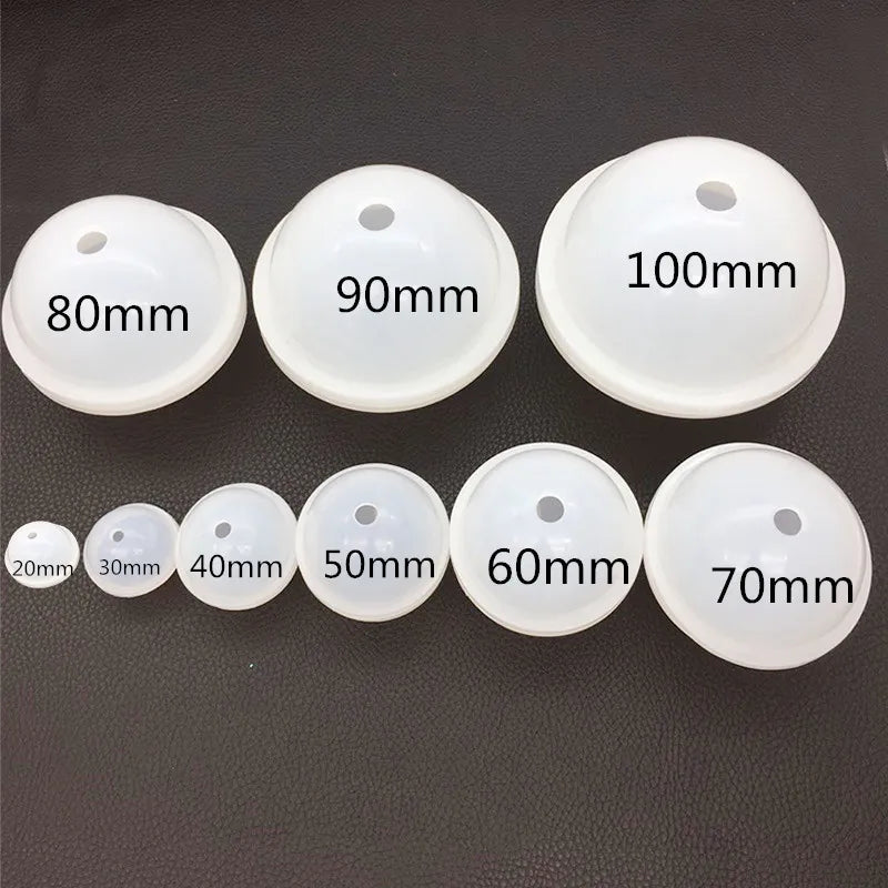 A collection of white silicone sphere molds with various diameters labeled in millimeters, ranging from 80mm to 100mm.