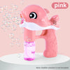 A pink whale bubble gun toy is shown against a light background with bubbles flying out.