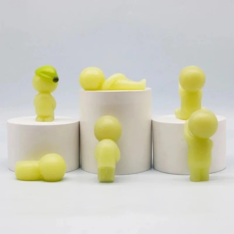 A collection of yellow glow-in-the-dark elf figures displayed in white cylindrical containers.