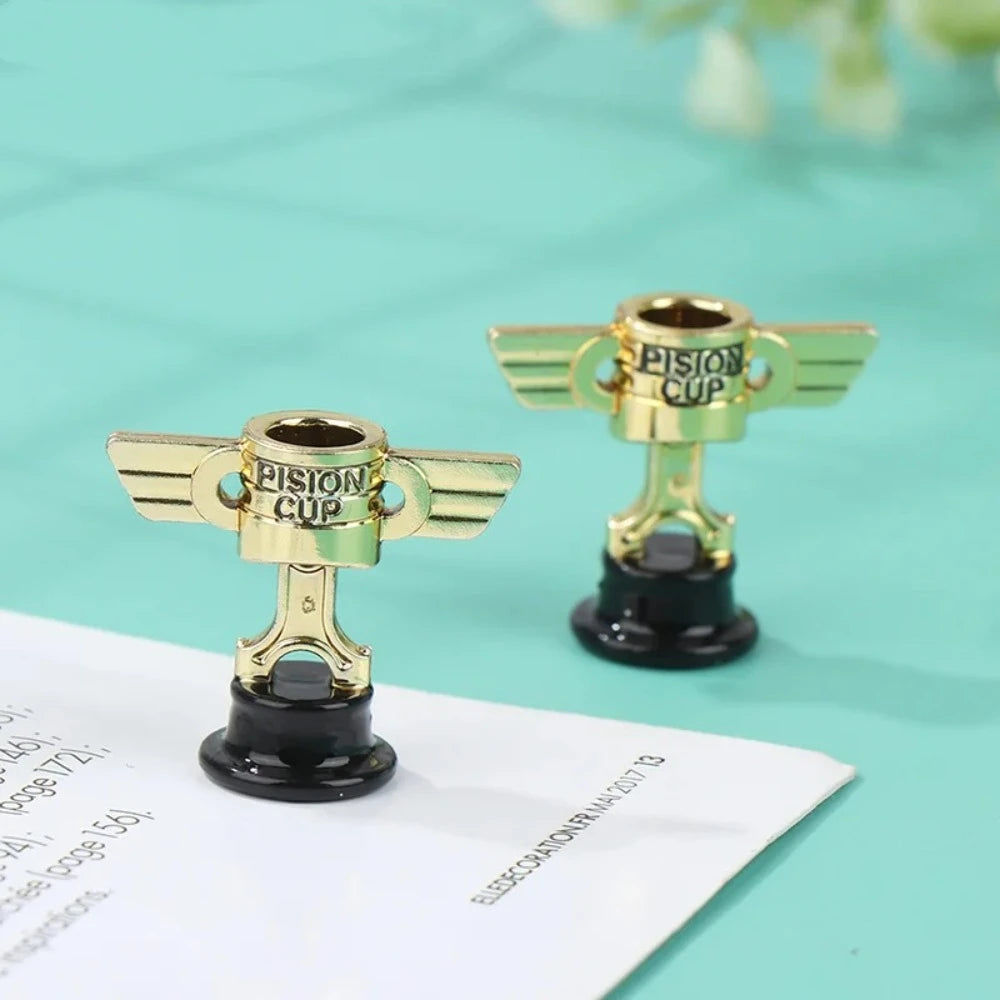 A miniature golden trophy cup with wings is displayed on a white card against a light blue background.