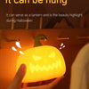 A hand holds a glowing orange pumpkin LED night light with a hook shape, highlighting its Halloween use.