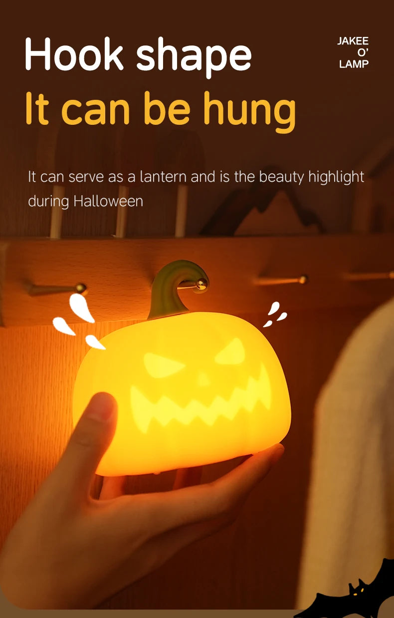 A hand holds a glowing orange pumpkin LED night light with a hook shape, highlighting its Halloween use.
