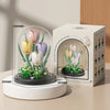 A set of building blocks forming an eternal bouquet of colorful flowers inside a clear glass enclosure.