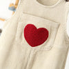 A beige corduroy toddler overalls featuring a red felt heart embroidery patch on the chest pocket.