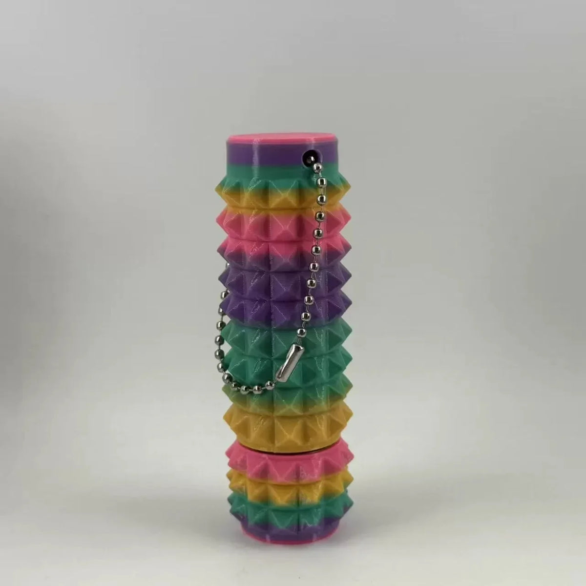 A stack of colorful, hexagonal spike rollers or fidget toys in shades of pink, purple, green, and yellow.