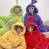 Three children dressed in Teletubbies-inspired hooded pajamas in green, purple, and yellow.