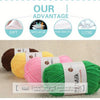 A pile of green acrylic yarn is shown next to other colored yarns on a light background.