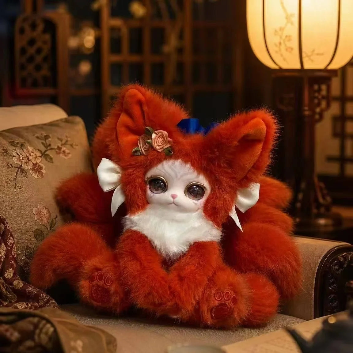 An adorable orange and white fox plush collectible with large eyes sitting on a textured surface.