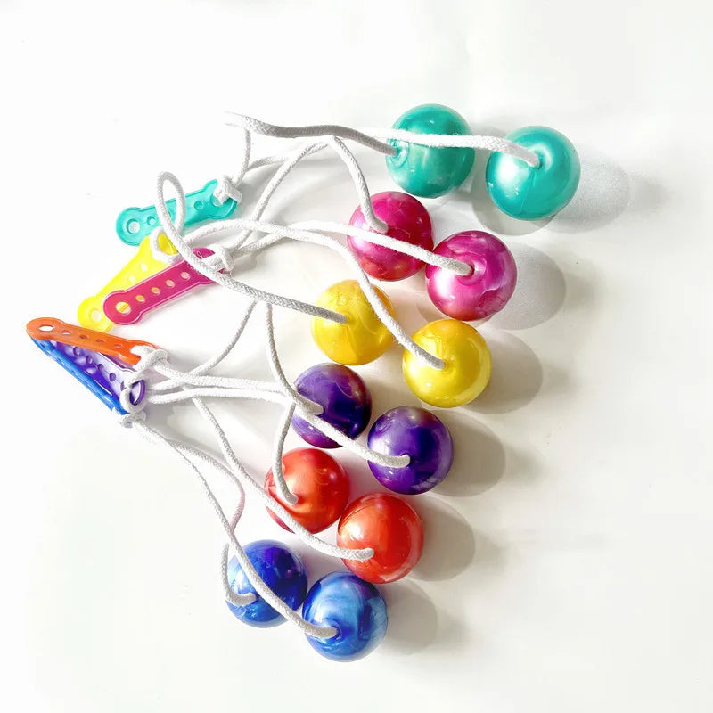 A string of colorful click clack fidget balls in shades of green, yellow, pink, and blue.