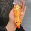 A hand holds an orange, squishy duck fidget toy with iridescent glitter and a small black eye.