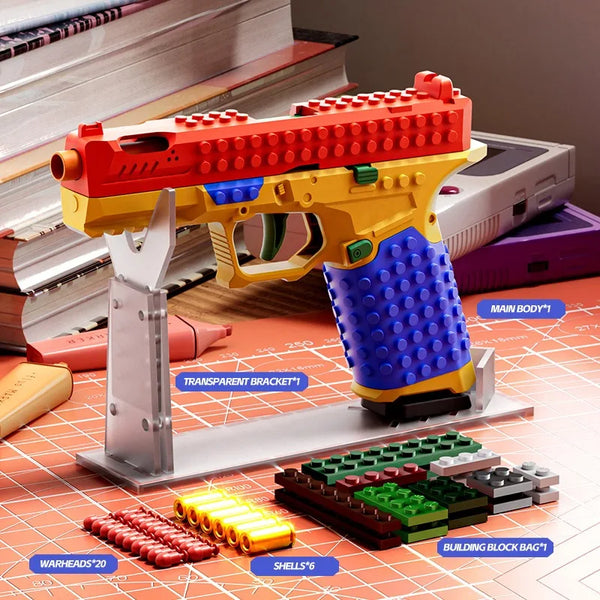 A yellow and red building block toy gun is displayed with various accessory pieces on a grid background.