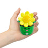 A hand holds a bright yellow flower toy with a green pot and a small number 1 on the bottom.