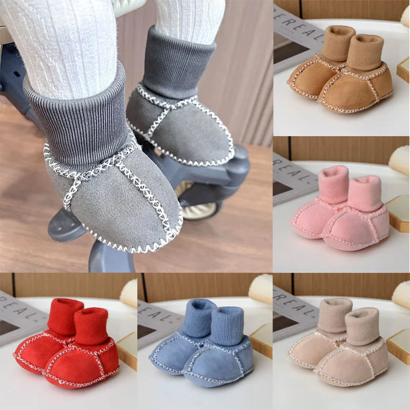 A collection of cozy suede baby booties in various colors including pink, red, blue, and beige with plush fur lining.