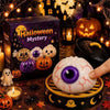 A Halloween themed squishy stress relief toy with a purple eye is displayed on a dark surface surrounded by spooky decoration