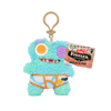 A light blue plush toy of a monster wearing an orange and white striped outfit, hanging from a gold-colored loop.