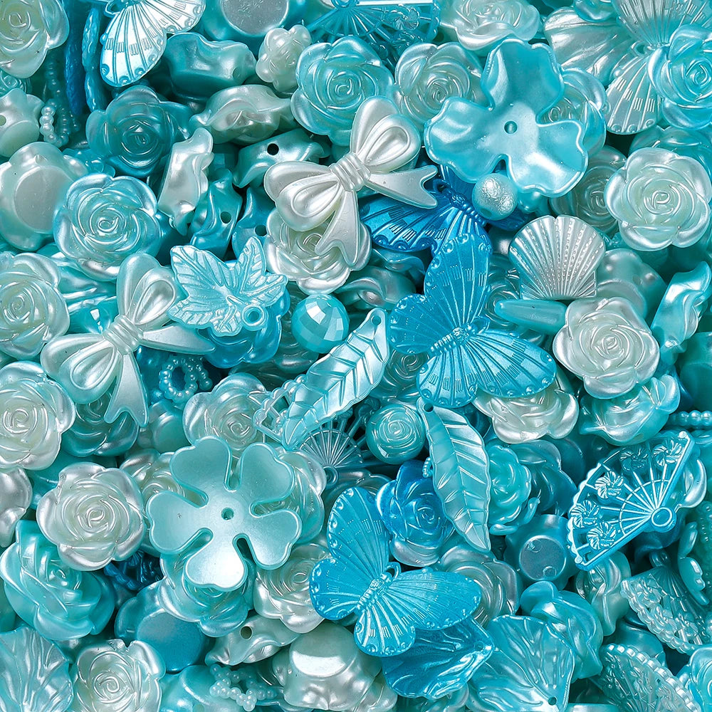A close-up of iridescent blue and silver butterfly shell acrylic beads for DIY jewelry making.
