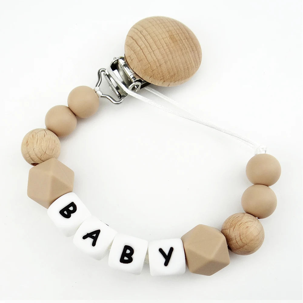 A necklace made of wooden and silicone beads with a clip, featuring the word BABY.