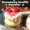 A strawberry soufflé squishy toy with pink meringue topping and fresh strawberries on a black tray.