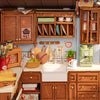 A miniature dollhouse kit featuring a cozy baking kitchen with wooden cabinets and accessories.