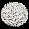 A pile of small white acrylic alphabet letter beads for jewelry making