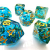 A collection of ocean blue resin dice with gold foil numbers scattered on a white surface.
