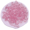 A pile of pink acrylic bow beads for jewelry making arranged on a white oval dish.