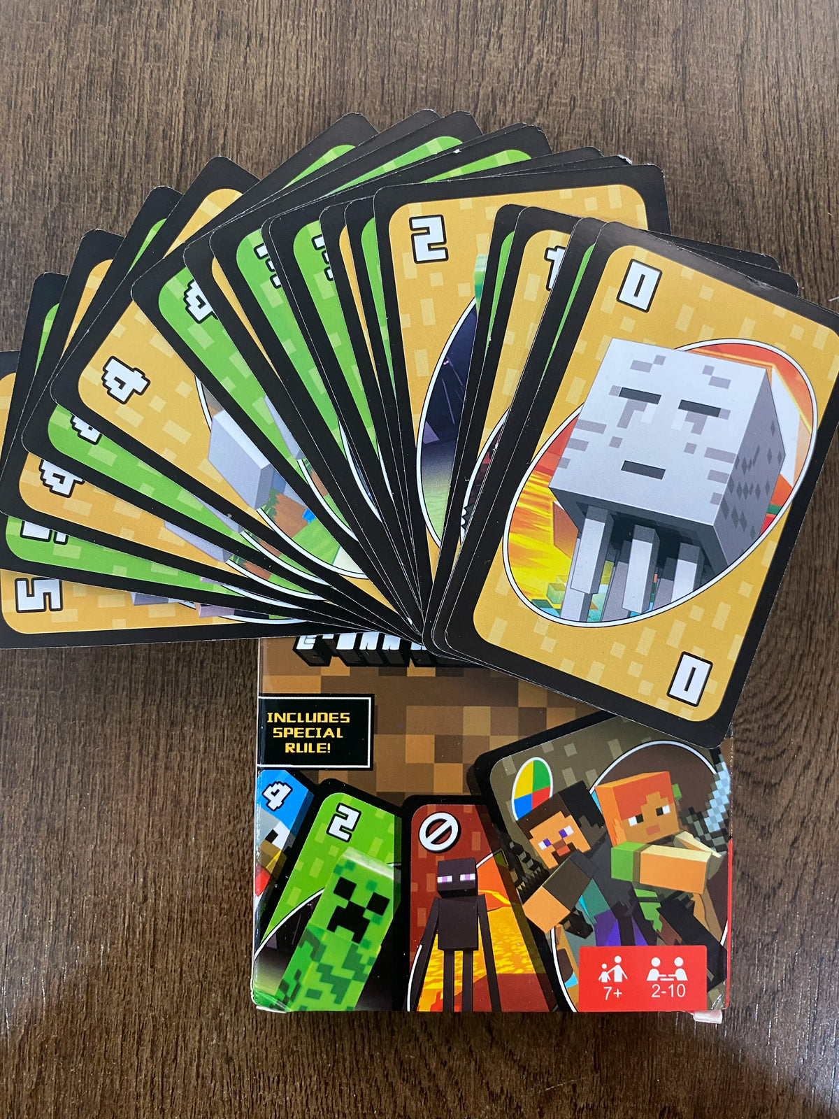 A stack of FLIP! matching cards featuring various numbered cards and a special rule card on a wooden surface.