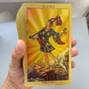 A golden foil tarot card titled El Loco featuring a figure labeled The Fool against a bright yellow background.