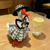 A set of miniature goose statues featuring a plaid dress and accessory with an orange beak