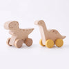 A wooden dinosaur toy car with yellow wheels for baby teethering.