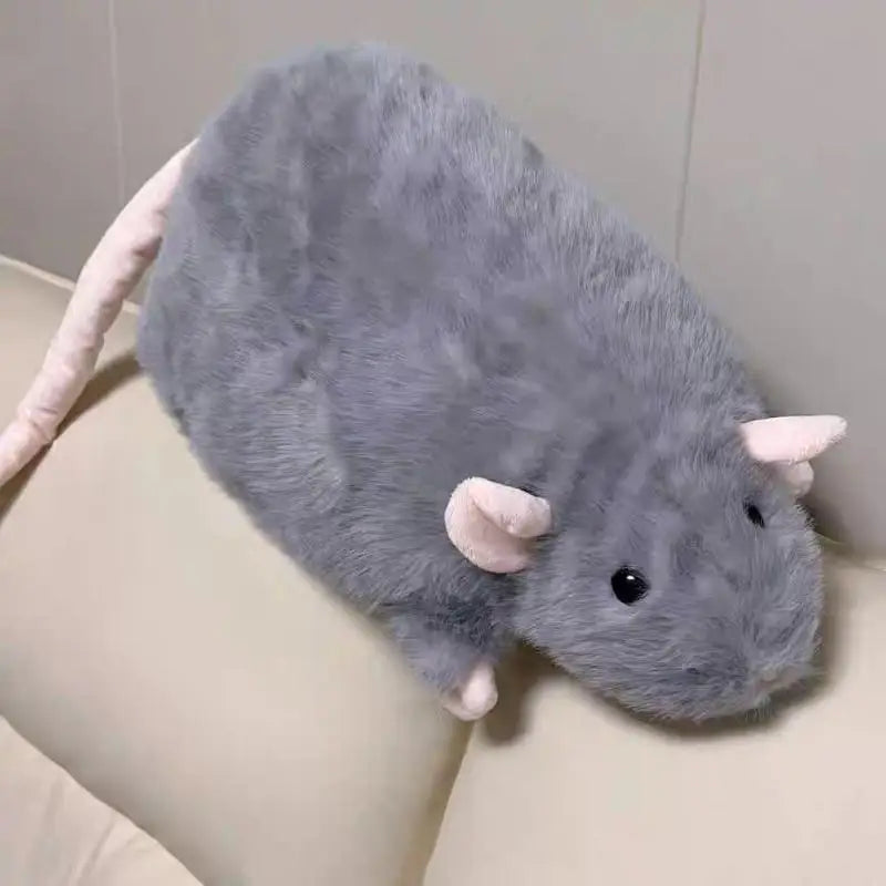 A realistic plush rat stuffed animal doll with gray fur and pink ears resting on a light-colored surface.