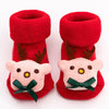 Pair of red baby anti-slip cotton socks with festive Christmas designs.