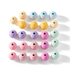 A collection of round matte acrylic beads in various pastel colors arranged in a row.