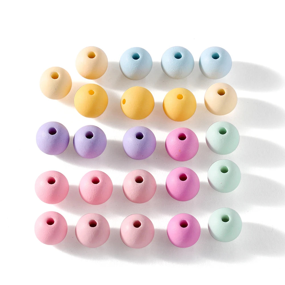 A collection of round matte acrylic beads in various pastel colors arranged in a row.
